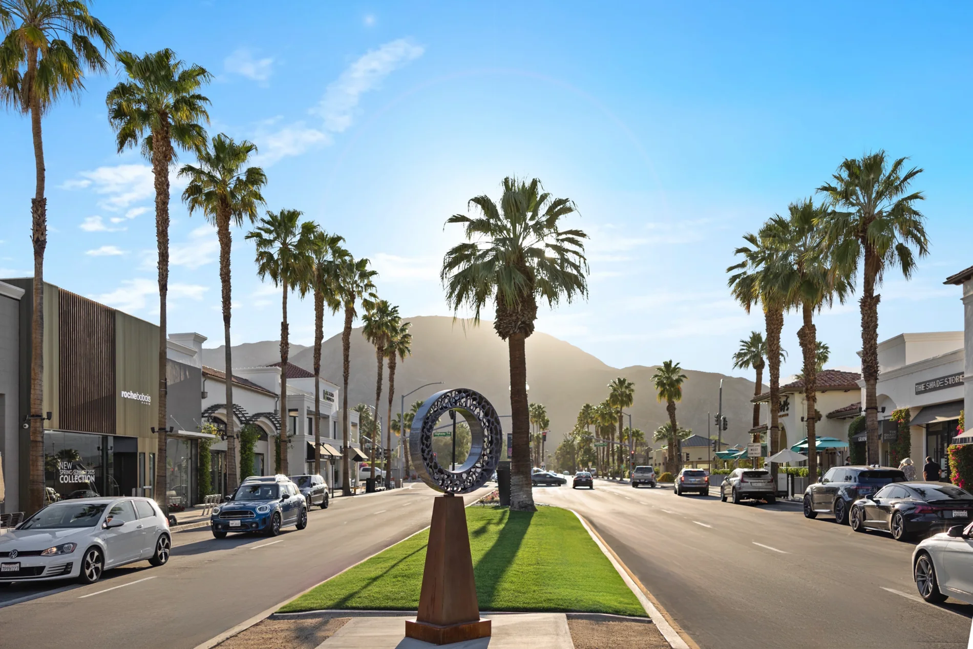 El Paseo at golden hour, palms and the sculpture median with the Santa Rosa Mountains beyond